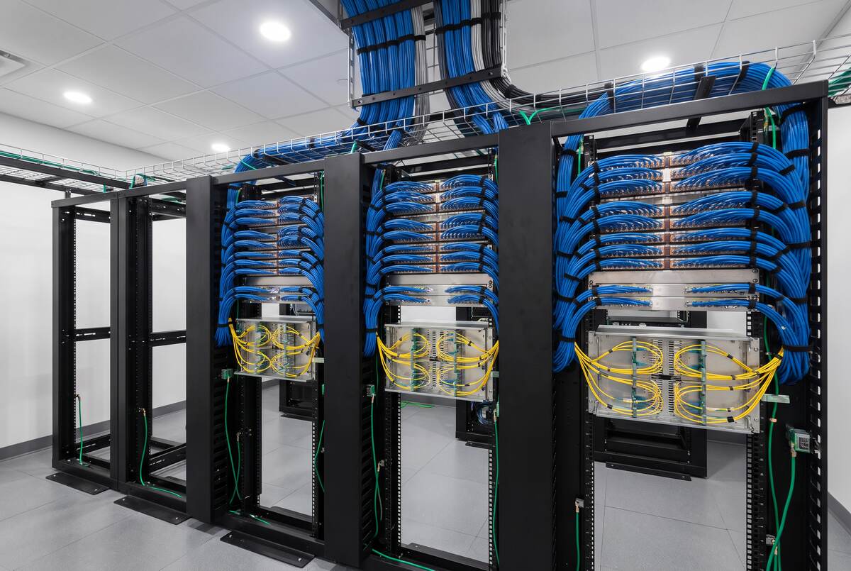 MDF racks with dressed Cat-6 patch panels, fiber enclosures, and overhead cable tray